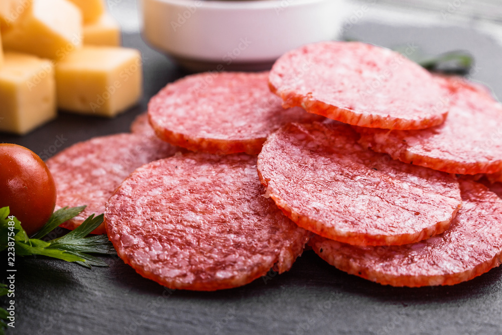 delicious sliced salami on a stone plate wooden background delicious sliced salami on a stone plate wooden background