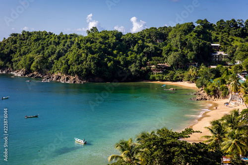 Beautiful tropical beach in Trinidad and Tobago, Caribe - blue sky, trees, sand beach, wood boats photo