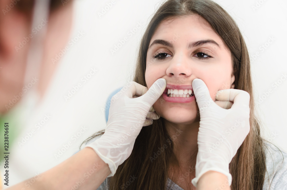Close up of dentist cheking on her patient's smile in office. Close up of dentist cheking on her patient's smile in office.