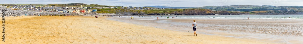 Beach in Lahinch with village in background
