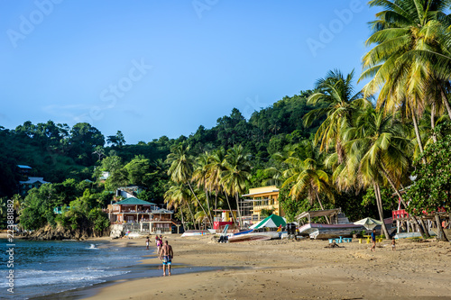 Fototapeta Naklejka Na Ścianę i Meble -  Few tourists enjoying a amazing tropical beach in the late sunset. Trinidad and Tobago, Caribe