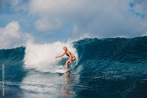 Surf girl at surfboard on barrel wave. Woman and surfing