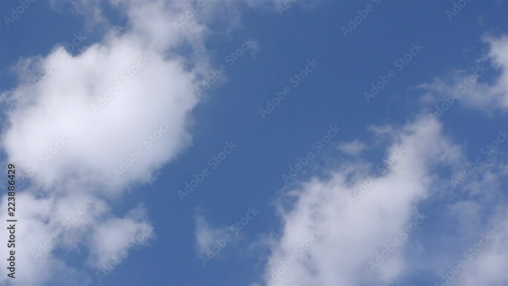 White fluffy clouds in the vast blue sky. Abstract nature background. Close-up. White fluffy clouds in the vast blue sky. Abstract nature background. Close-up.