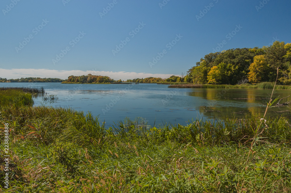 Peaceful late summer landscape of water and trees in Monson Lake State Park in Minnesota