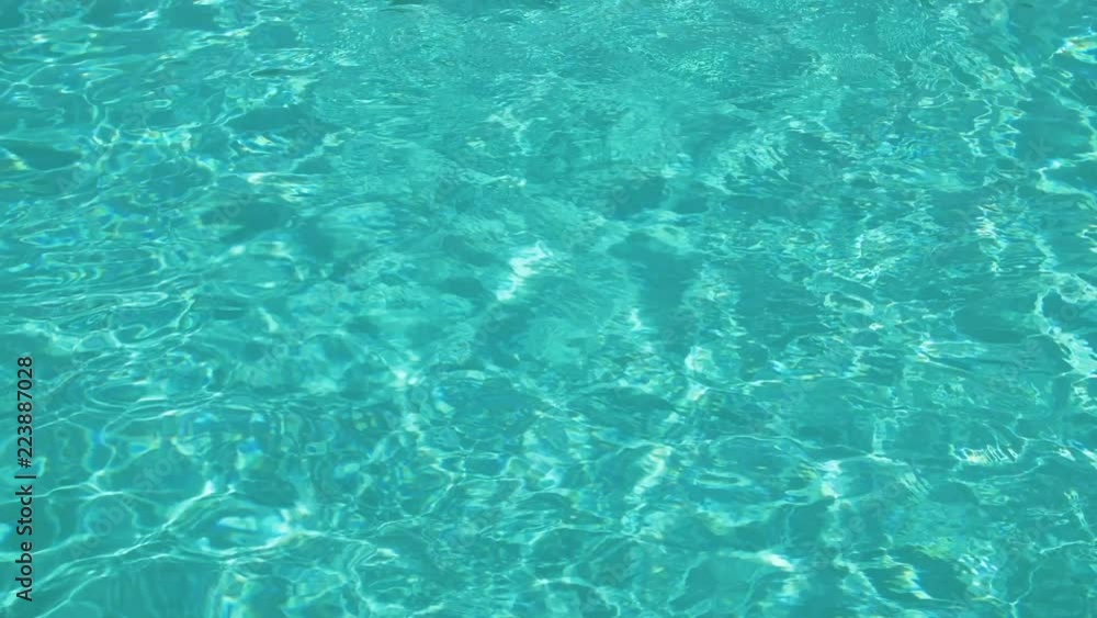 Pure blue water in pool with light reflections. Slow motion. Ripples below the water surface Pure blue water in pool with light reflections. Slow motion. Ripples below the water surface