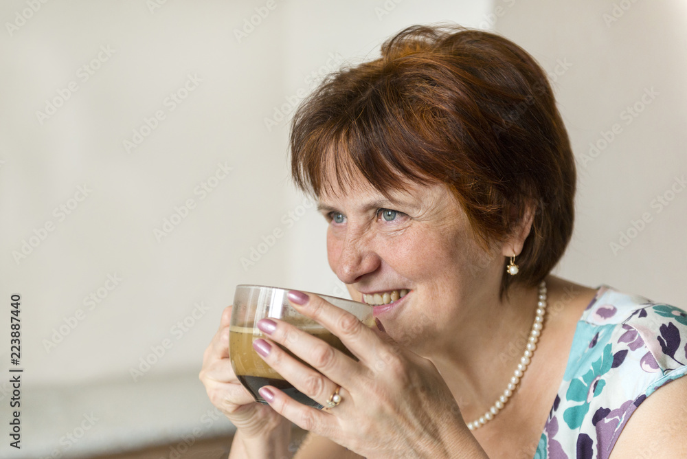 white adult woman drinks black coffee from mug and smiles white adult woman drinks black coffee from mug and smiles