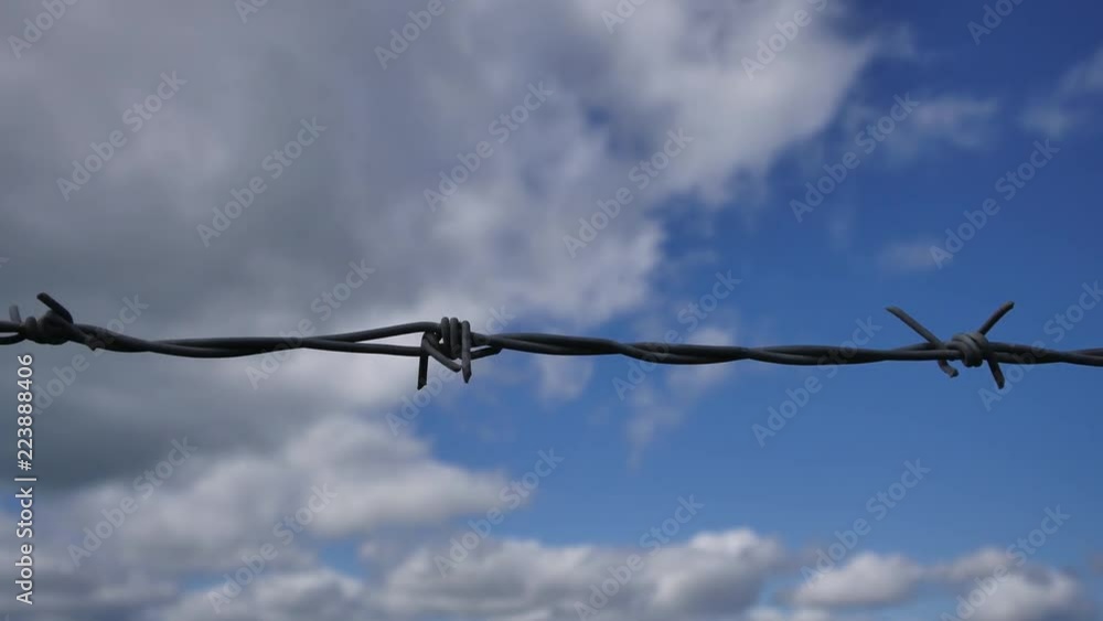 Time Lapse of a barbed wire, blue sky in the background and white clouds, 4K resolution Time Lapse of a barbed wire, blue sky in the background and white clouds, 4K resolution