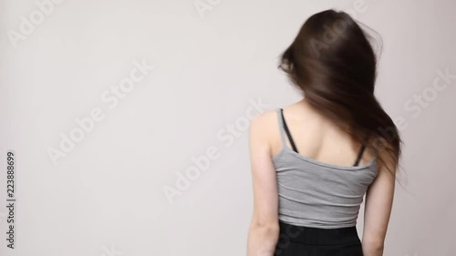 Woman play with her hair isolated on gray