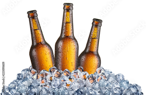 Three cold bottles of beer in the ice cubes.