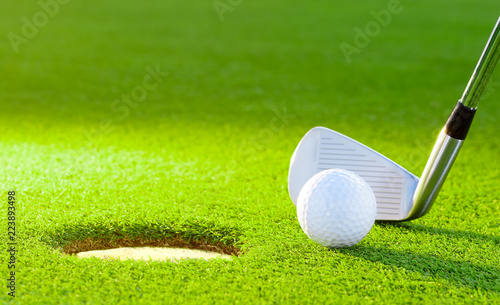 golf ball from the hole with the putter on golf turf