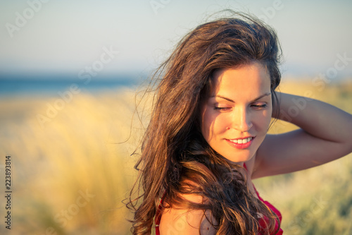 Outdoor portrait of attractive young woman enjoying evening sun © sborisov
