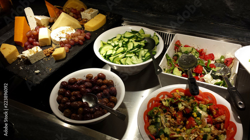 Greek salads, olives, sliced cucumbers and various cheeses.