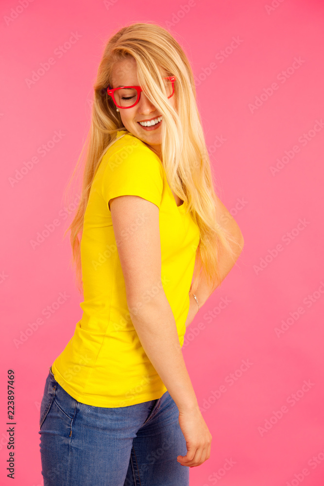 Portrait of a funky young woman in yellow t shirt over pink background Portrait of a funky young woman in yellow t shirt over pink background