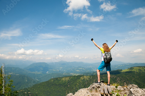 Active woman gesturing success after climbing a mountain