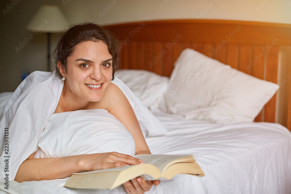 Young woman reading book in bed Young woman reading book in bed