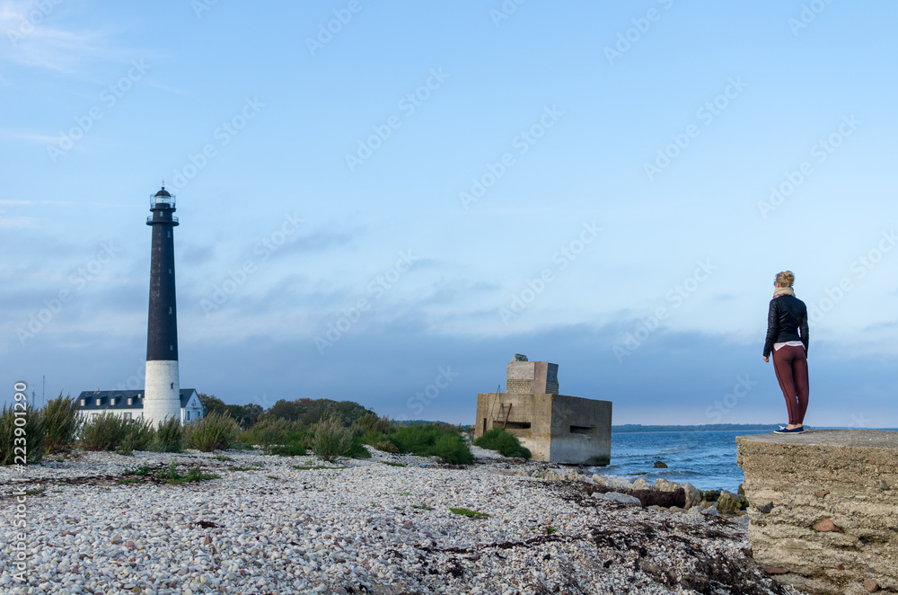 Woman at the Sõrve Lighthouse by the Baltic Sea in the island of Saaremaa, Estonia