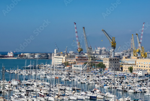 tourist and commercial boats moored in neat rows in the port of Genoa, Liguria. Italy