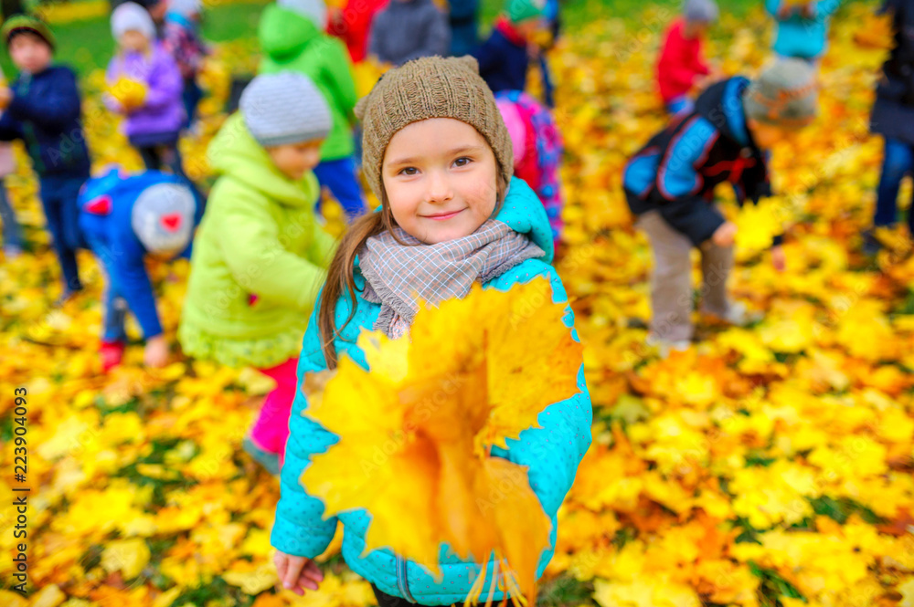 Children playing in the autumn park, the girl shows a bouquet of autumn leaves Children playing in the autumn park, the girl shows a bouquet of autumn leaves