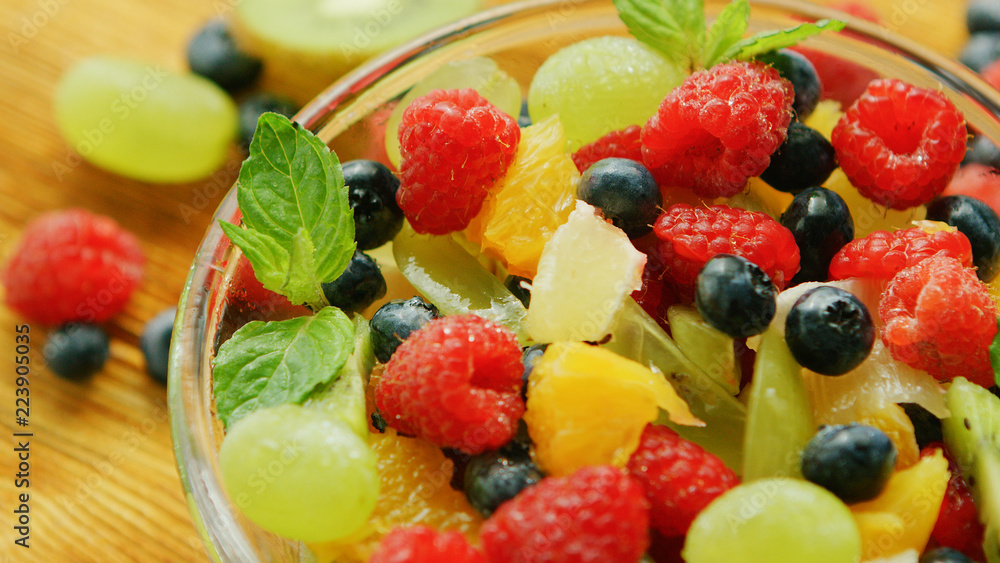 Closeup shot of sweet mix of assortment of berries and fruit served in salad in bowl on table Closeup shot of sweet mix of assortment of berries and fruit served in salad in bowl on table