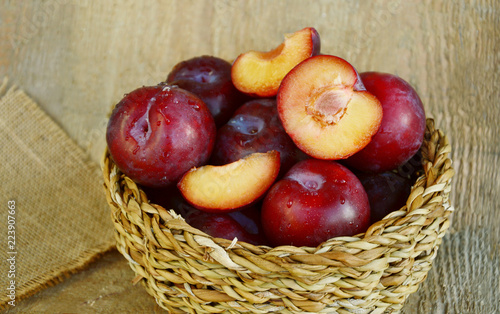 Plum Benefits Your Digestion & Cardiovascular Health.
Many Plums(German name is Pflaumen dunkel ) in basket on wooden background.