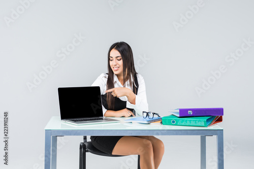 Young business woman on a laptop at working desk isolated on white background