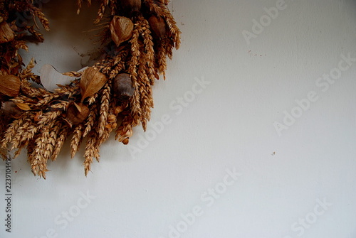 Detail of strawy wreath with dried physalis peruviana as a decoration on white wall photo