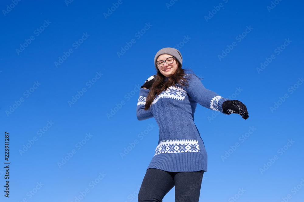 girl in a warm sweater throws snow and bask in the winter sun girl in a warm sweater throws snow and bask in the winter sun
