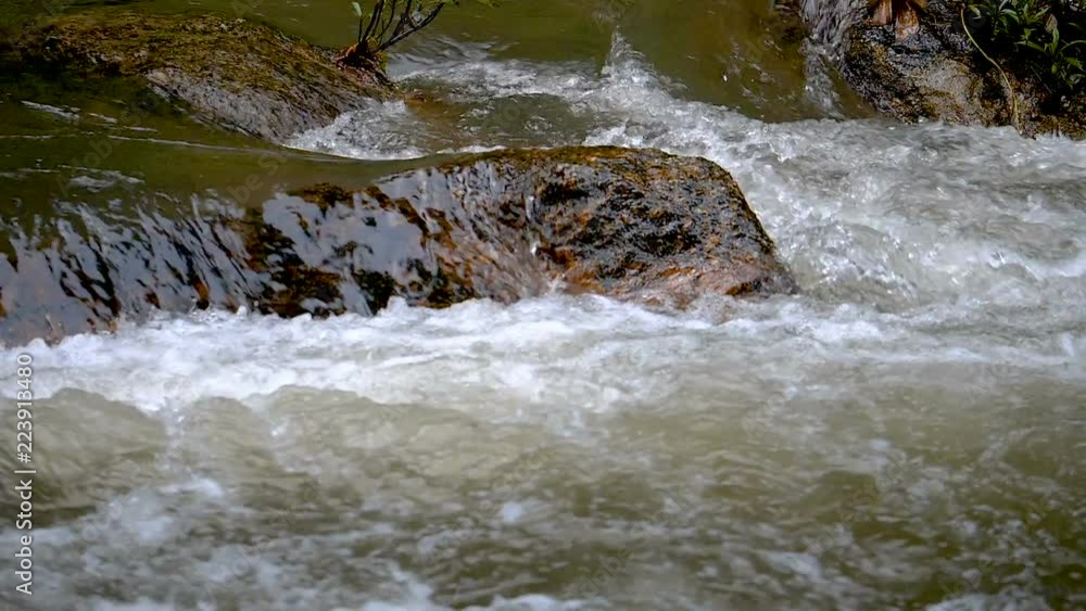 Slow motion video of close up water flowing / splashing / waterfall from the rock in the forest. (High Speed Video) Slow motion video of close up water flowing / splashing / waterfall from the rock in the forest. (High Speed Video)