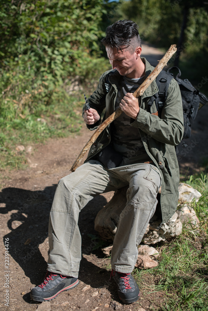 hiker preparing stick from old branch