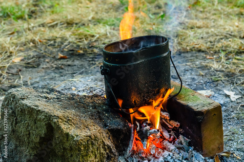 Cooking food in a kettle on bonfire