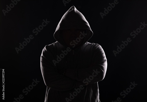 studio portrait of a guy in a hood on a black background