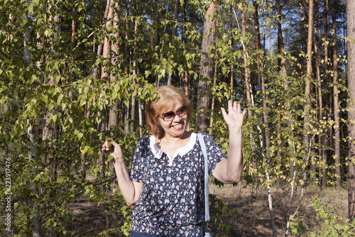 Portrait of a mature woman near small birches