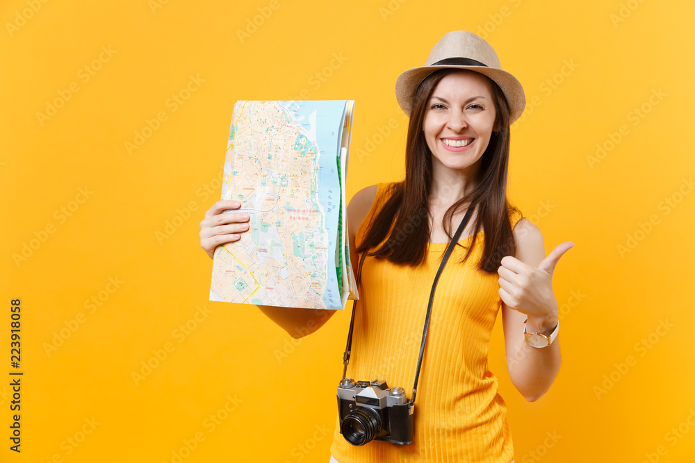 Traveler tourist woman in summer casual clothes, hat holding city map isolated on yellow orange background. Female passenger traveling abroad to travel on weekends getaway. Air flight journey concept. Traveler tourist woman in summer casual clothes, hat holding city map isolated on yellow orange background. Female passenger traveling abroad to travel on weekends getaway. Air flight journey concept.