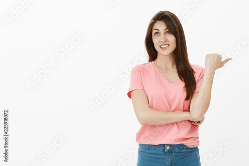 Studio shot of shocked happy young woman talking about something unimpressive, expressing careless opinion about new concept coworker suggested during meeting, smiling and looking up with indifference