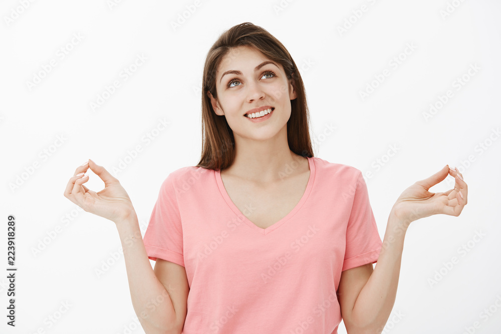 Lifestyle and emotions concept. Portrait of optimistic relaxed young woman in casual outfit spreading hands in zen gesture smiling and looking up with relieved expression, meditating during yoga Lifestyle and emotions concept. Portrait of optimistic relaxed young woman in casual outfit spreading hands in zen gesture smiling and looking up with relieved expression, meditating during yoga