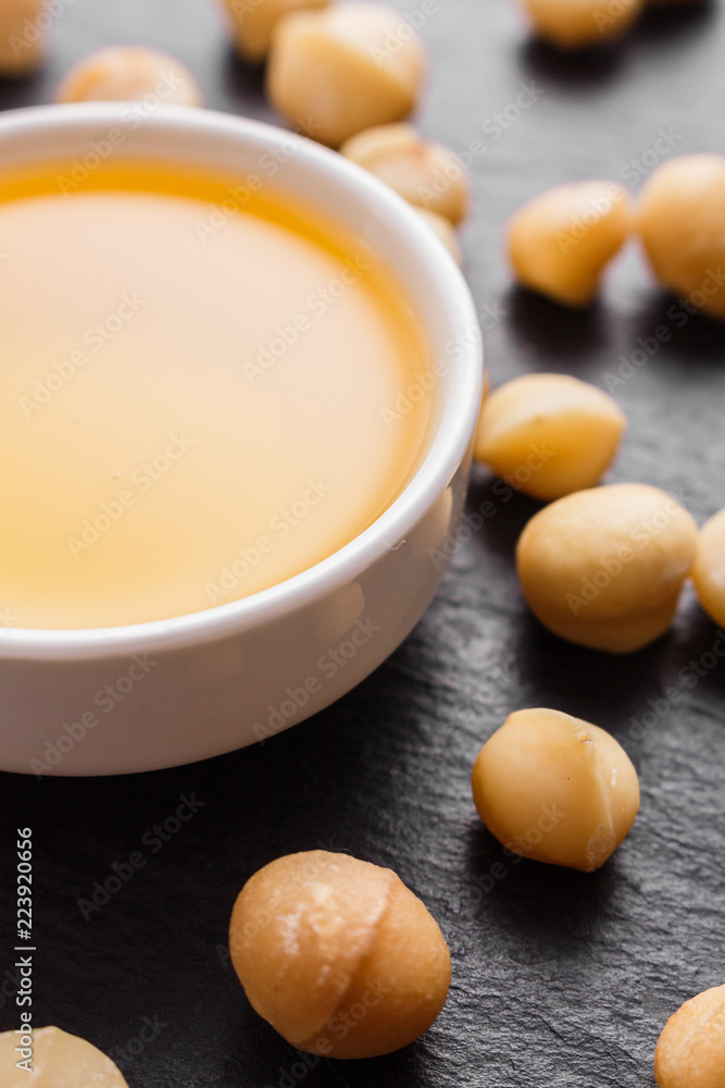 delicious macadamia nuts on a dark stone background delicious macadamia nuts on a dark stone background