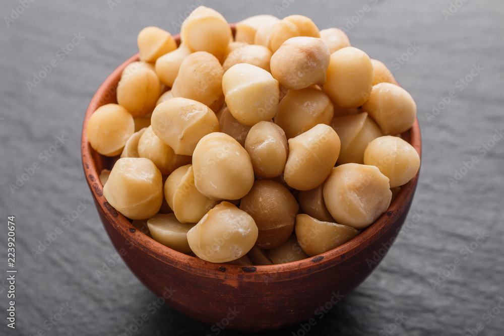 delicious macadamia nuts on a dark stone background delicious macadamia nuts on a dark stone background