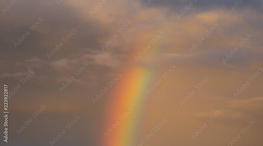 Rainbow at Sunset with a Cloudy Sky, Amazing Background.