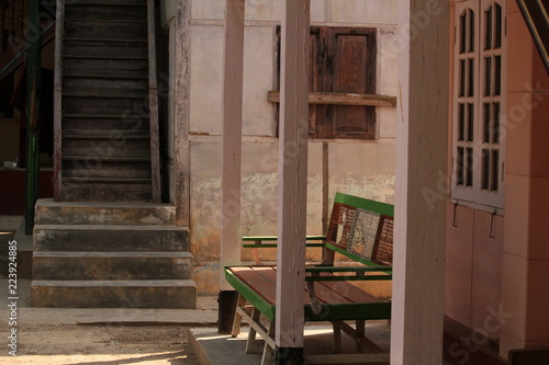 Backyard image showing an abandoned bench and stairway at a buddhist temple monastery on a sunny afternoon in Sagaying Mandalay, Myanmar, Burma, Asia