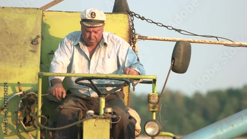 Mature redneck driving combine. Agricultaral work concept. photo