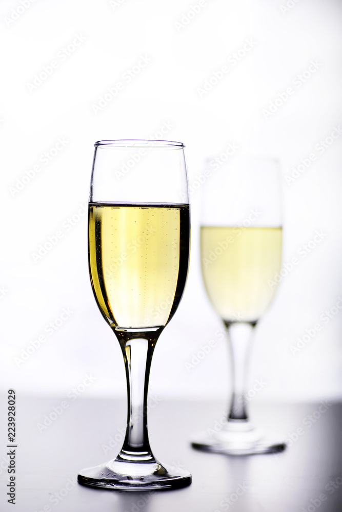 glass of white wine on a table on white background isolate glass of white wine on a table on white background isolate