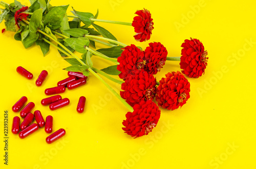 Medical herbal capsules of red color on bright background, alternative medicine photo