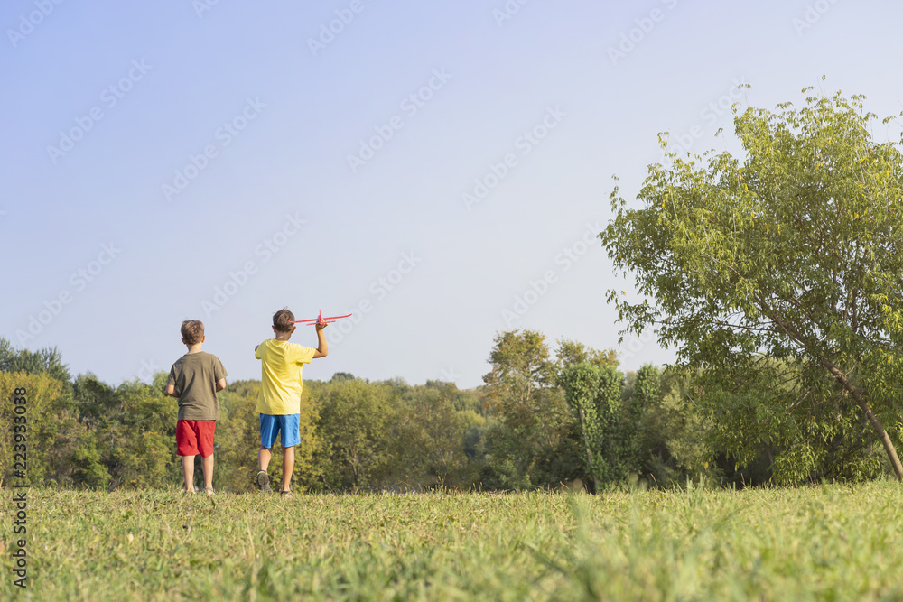 Children playingg red airplane in park green grace and sky Children playingg red airplane in park green grace and sky