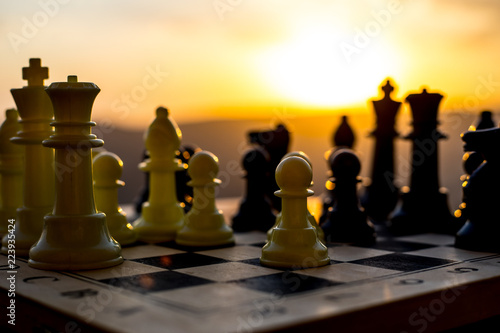 chess board game concept of business ideas and competition and strategy ideas. Chess figures on a chessboard outdoor sunset background.