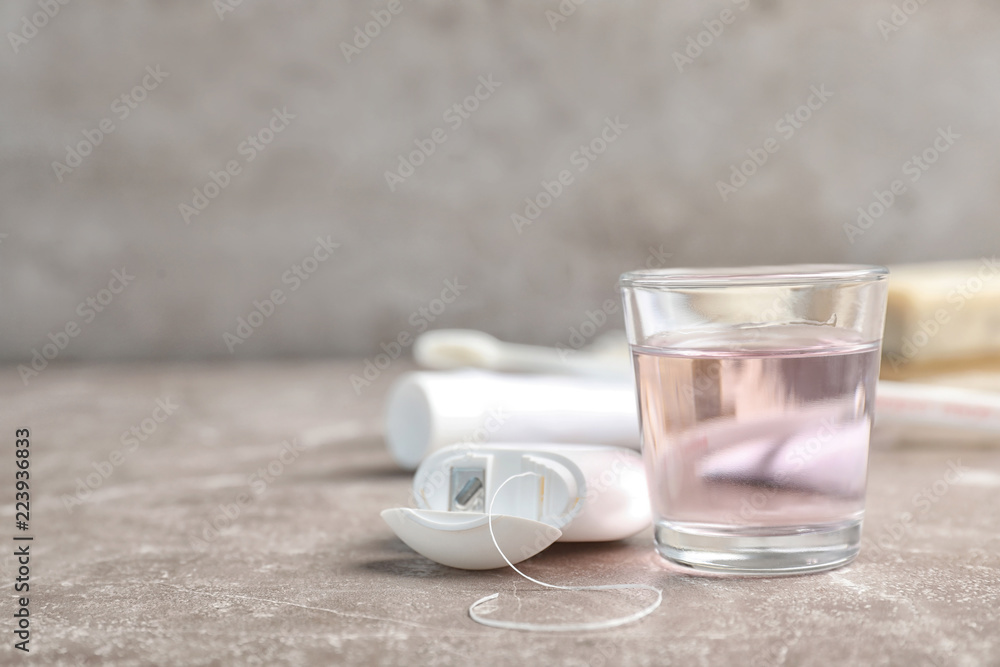 Glass with mouthwash and dental floss on table. Teeth hygiene Glass with mouthwash and dental floss on table. Teeth hygiene