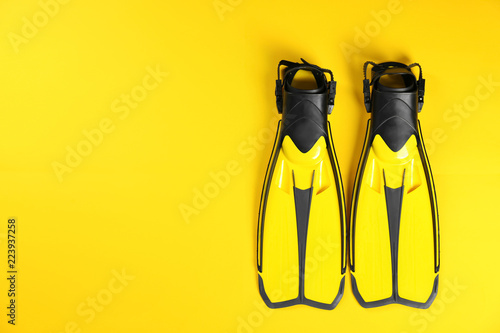 Swimming flippers on color background, top view. Space for text