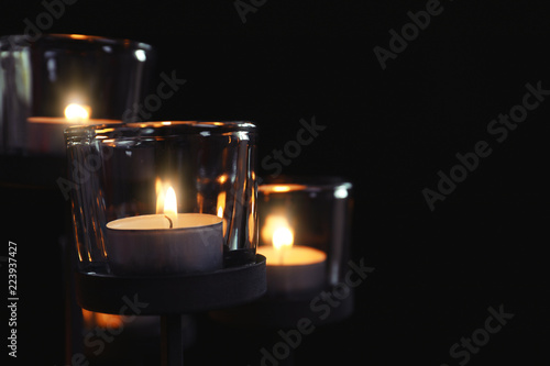 Burning candles on dark background. Funeral symbol