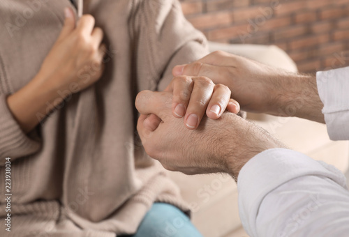 Man holding woman's hand indoors, closeup. Concept of support and help
