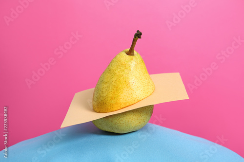 Creative composition with fresh ripe pear against color background