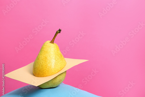 Creative composition with fresh ripe pear and space for text against color background